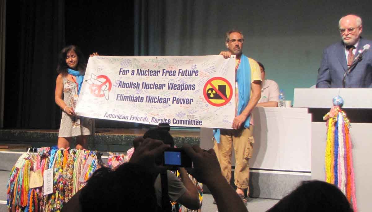 Mary Lou and Jim holding banner in Nagasaki for AFSC's Joe Gerson